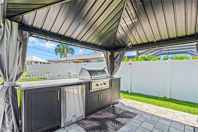 6212 Cocos Dr, Fort Myers, FL 33908 - view of patio featuring grilling area, a fenced backyard, and exterior kitchen
