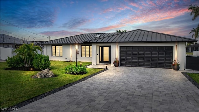 6212 Cocos Dr, Fort Myers, FL 33908 - view of front of house with a standing seam roof, stucco siding, a garage, and decorative driveway