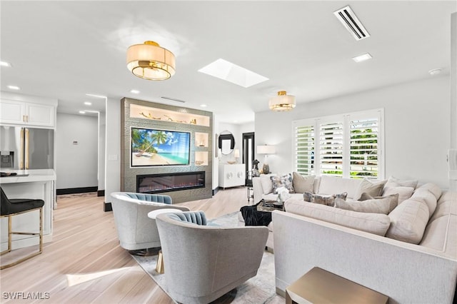 6212 Cocos Dr, Fort Myers, FL 33908 - living area with a skylight, a glass covered fireplace, light wood-style floors, and recessed lighting