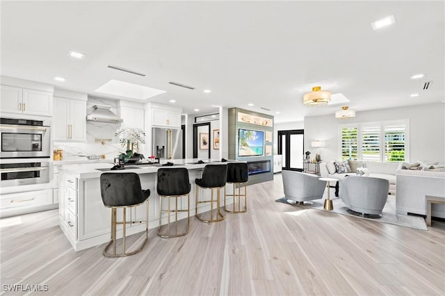 6212 Cocos Dr, Fort Myers, FL 33908 - kitchen featuring stainless steel appliances, open floor plan, light countertops, white cabinetry, and light wood finished floors