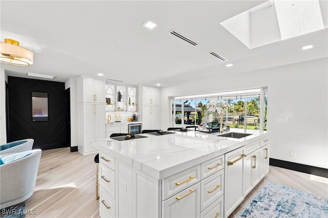 6212 Cocos Dr, Fort Myers, FL 33908 - kitchen with a spacious island, white cabinets, light wood finished floors, light stone counters, and recessed lighting
