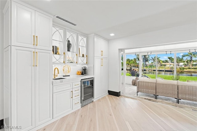 6212 Cocos Dr, Fort Myers, FL 33908 - indoor dry bar featuring wine cooler, a water view, light wood-type flooring, recessed lighting, and baseboards