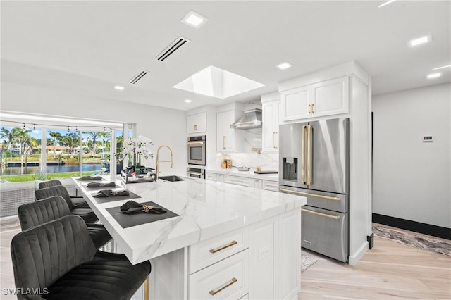 6212 Cocos Dr, Fort Myers, FL 33908 - kitchen with appliances with stainless steel finishes, a skylight, a sink, white cabinetry, and light stone countertops