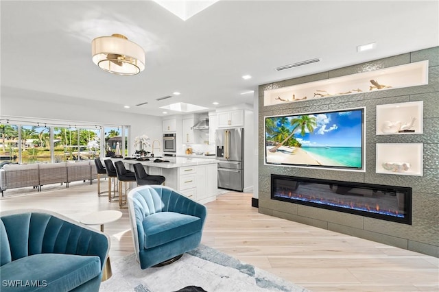 6212 Cocos Dr, Fort Myers, FL 33908 - living room with a glass covered fireplace, light wood-style flooring, and recessed lighting