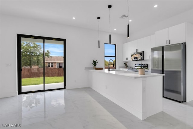 2003 Curry Ave N, Lehigh Acres, FL 33971 - kitchen with stainless steel appliances, a sink, light marble finish flooring, modern cabinets, and white cabinetry