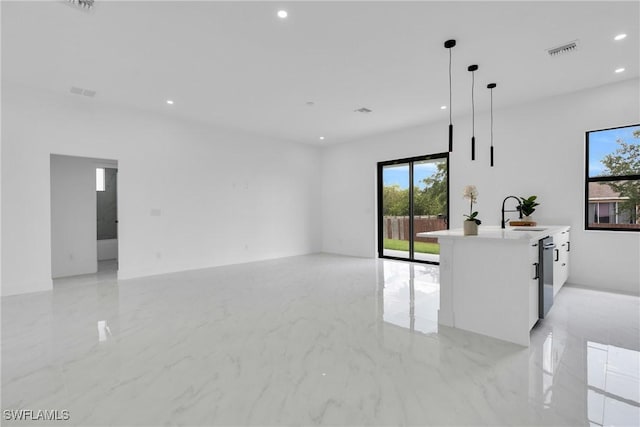 2003 Curry Ave N, Lehigh Acres, FL 33971 - unfurnished living room with recessed lighting, a sink, and light marble finish floors