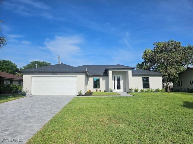 27584 Playa Del Rey Ln, Bonita Springs, FL 34135 - prairie-style home with stucco siding, an attached garage, decorative driveway, and a front lawn