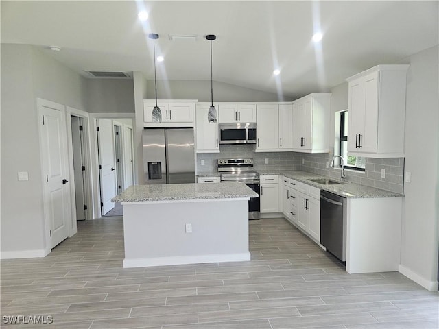 27584 Playa Del Rey Ln, Bonita Springs, FL 34135 - kitchen featuring stainless steel appliances, tasteful backsplash, light wood-type flooring, and vaulted ceiling