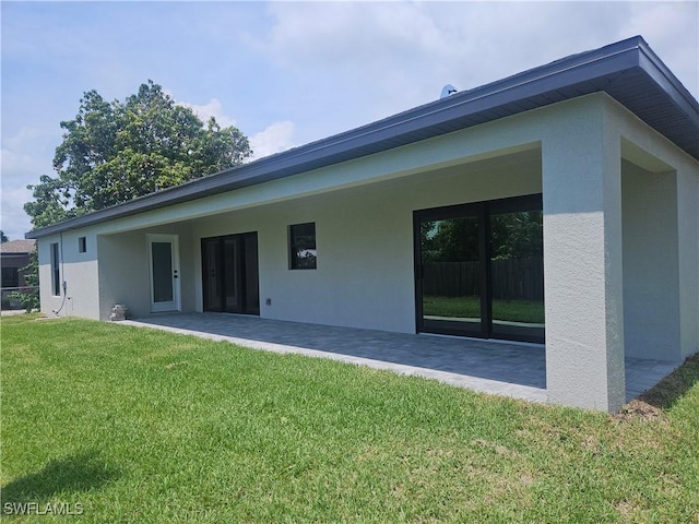 27584 Playa Del Rey Ln, Bonita Springs, FL 34135 - back of house featuring a patio area, a yard, and stucco siding