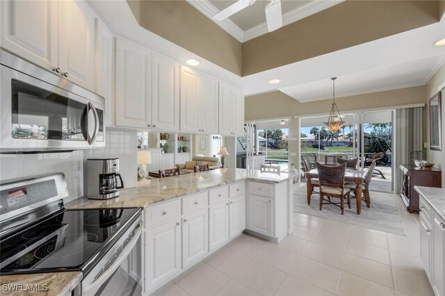 3774 Whidbey Way, Naples, FL 34119 - kitchen with appliances with stainless steel finishes, ornamental molding, a peninsula, light tile patterned flooring, and white cabinetry