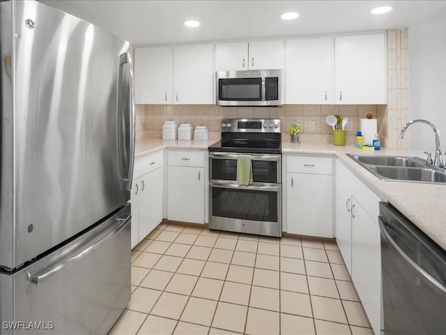 901 Collier Ct Unit 5-205, Marco Island, FL 34145 - kitchen with appliances with stainless steel finishes, a sink, light countertops, tasteful backsplash, and white cabinets