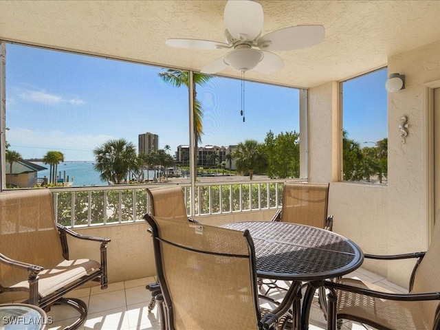 901 Collier Ct Unit 5-205, Marco Island, FL 34145 - sunroom / solarium with ceiling fan, a water view, tile patterned floors, a textured ceiling, and outdoor dining area