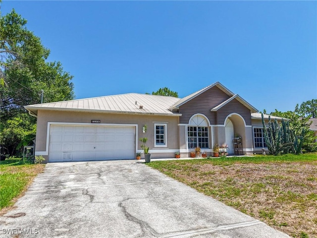 5208 Bygone St, Lehigh Acres, FL 33971 - ranch-style home with stucco siding, a garage, driveway, metal roof, and a front yard