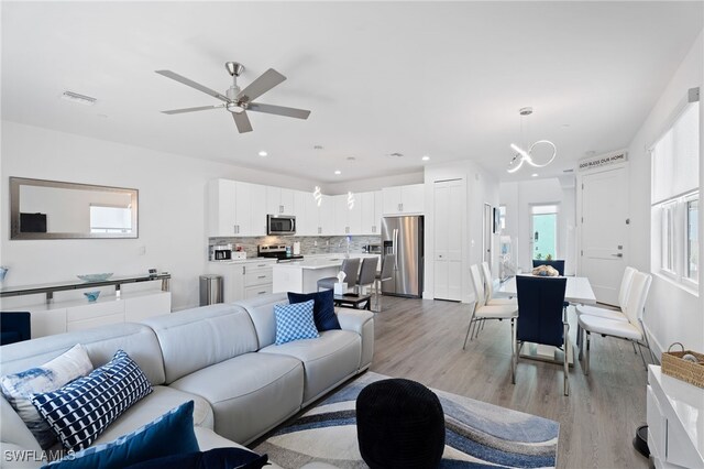 5851 Shell Cove Dr Unit 101A, Cape Coral, FL 33914 - living room featuring light wood finished floors, a ceiling fan, recessed lighting, and a chandelier