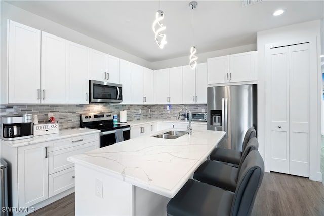 5851 Shell Cove Dr Unit 101A, Cape Coral, FL 33914 - kitchen featuring stainless steel appliances, a sink, wood finished floors, decorative backsplash, and recessed lighting