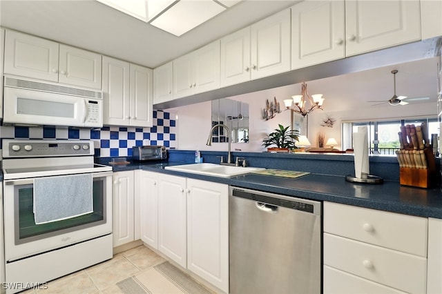 16000 Bay Pointe Blvd Unit 307, North Fort Myers, FL 33917 - kitchen featuring white appliances, a sink, dark countertops, and white cabinetry