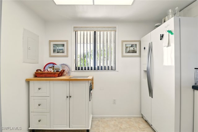 16000 Bay Pointe Blvd Unit 307, North Fort Myers, FL 33917 - kitchen featuring white refrigerator with ice dispenser, electric panel, baseboards, and white cabinetry