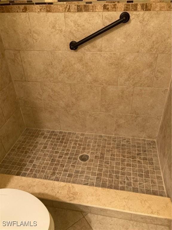 bathroom featuring a tile shower and toilet