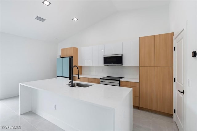 619 Greenbriar Blvd, Lehigh Acres, FL 33972 - kitchen featuring stainless steel appliances, a sink, modern cabinets, light tile patterned floors, and a center island with sink