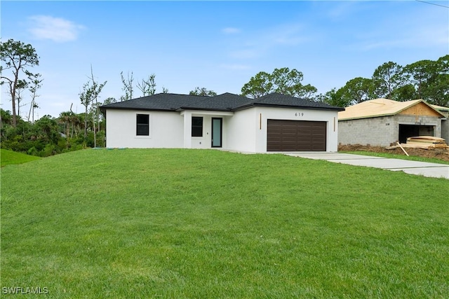 619 Greenbriar Blvd, Lehigh Acres, FL 33972 - prairie-style home with stucco siding, an attached garage, driveway, and a front lawn