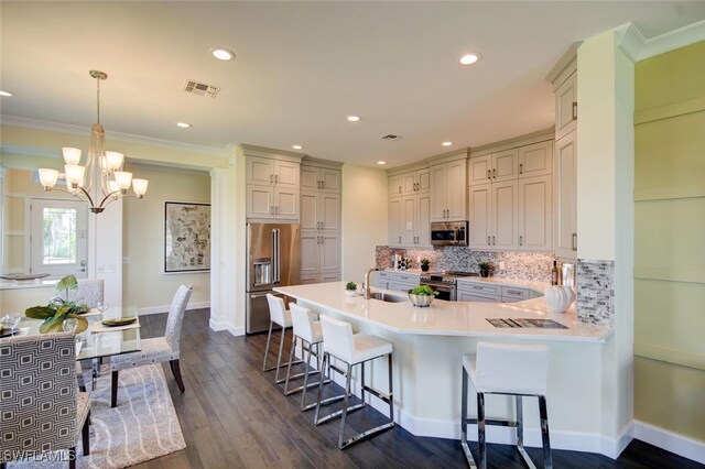 8881 Yucatan Ct, Naples, FL 34112 - kitchen featuring appliances with stainless steel finishes, a peninsula, a breakfast bar, tasteful backsplash, and light countertops