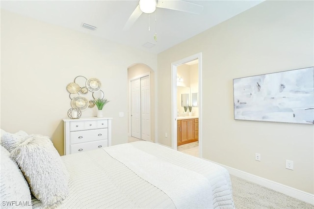 12490 Kentwood Ave, Fort Myers, FL 33913 - bedroom with arched walkways, baseboards, a closet, ensuite bath, and light carpet