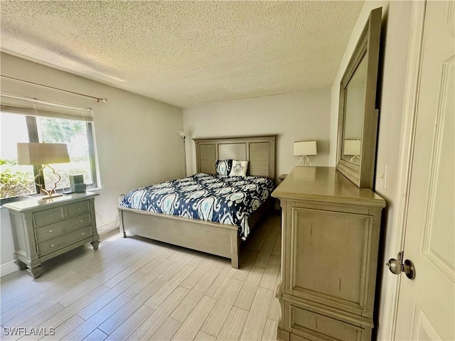 3625 Boca Ciega Dr Unit 110, Naples, FL 34112 - bedroom with a textured ceiling and light wood-style floors