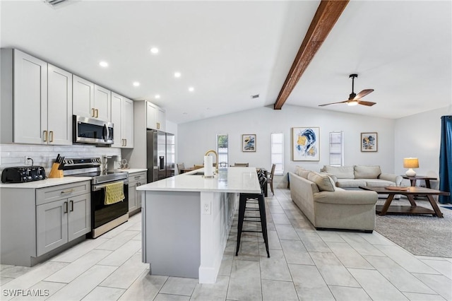 17365 Butler Rd, Fort Myers, FL 33967 - kitchen featuring stainless steel appliances, a sink, a breakfast bar, ceiling fan, and light countertops
