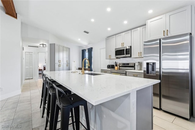 17365 Butler Rd, Fort Myers, FL 33967 - kitchen featuring appliances with stainless steel finishes, a sink, a large island with sink, light stone counters, and backsplash