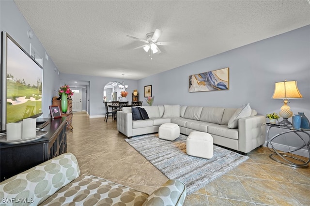 1210 Yesica Ann Cir Unit C105, Naples, FL 34110 - living room featuring a textured ceiling, a ceiling fan, and a chandelier