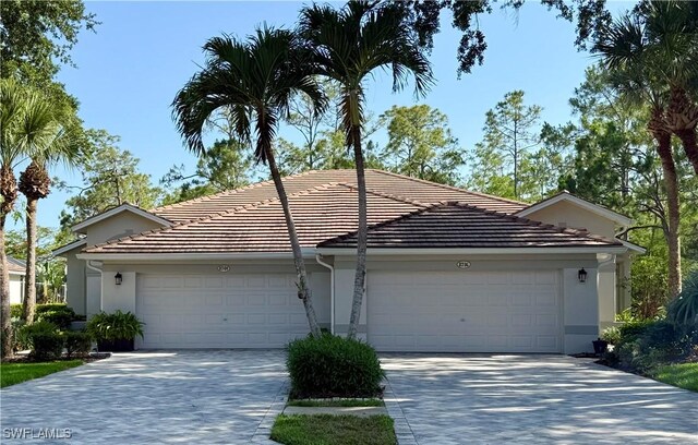 8736 Naples Heritage Dr, Naples, FL 34112 - ranch-style house featuring stucco siding, driveway, a tiled roof, and an attached garage