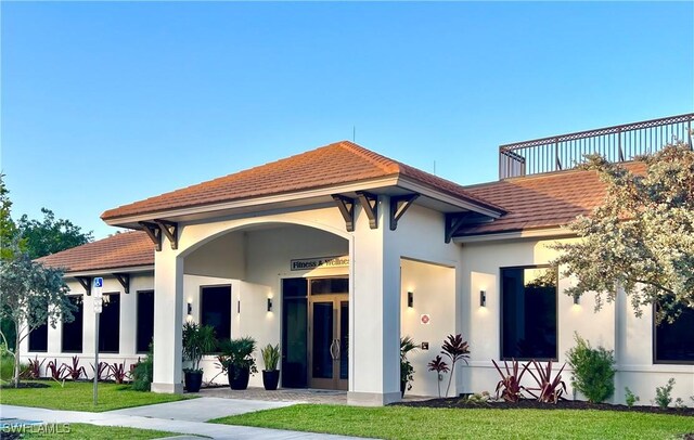 8736 Naples Heritage Dr, Naples, FL 34112 - view of front of house featuring a tile roof, stucco siding, and a front yard