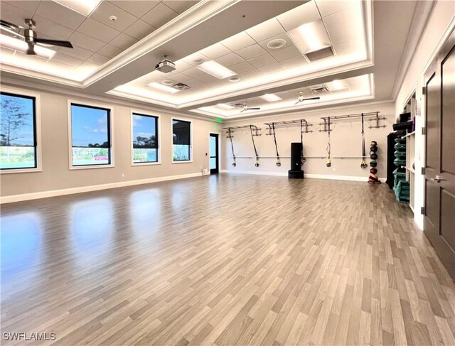 8736 Naples Heritage Dr, Naples, FL 34112 - gym with a tray ceiling, baseboards, wood finished floors, plenty of natural light, and ornamental molding