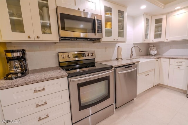 7150 Estero Blvd Unit 403, Fort Myers Beach, FL 33931 - kitchen with appliances with stainless steel finishes, a sink, backsplash, light stone counters, and light tile patterned floors