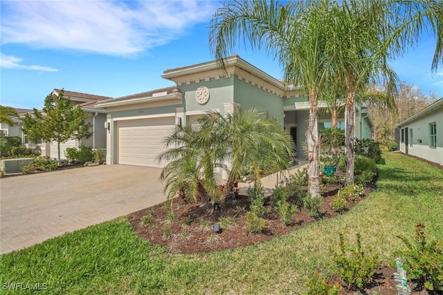 16712 Gilroy St, Bonita Springs, FL 34135 - view of front of home featuring decorative driveway, stucco siding, a garage, and a front yard