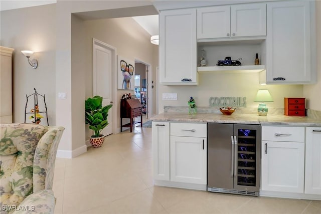 16712 Gilroy St, Bonita Springs, FL 34135 - kitchen with wine cooler, open shelves, white cabinetry, light stone countertops, and light tile patterned floors