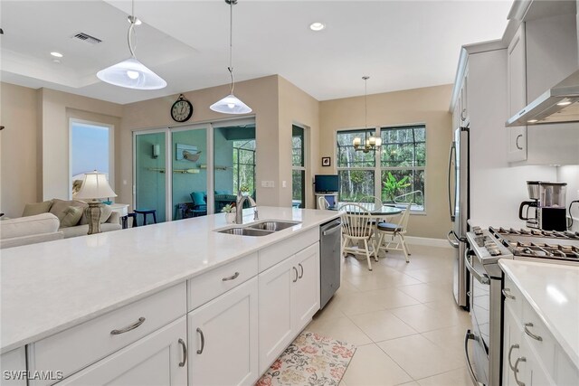 16712 Gilroy St, Bonita Springs, FL 34135 - kitchen with a sink, stainless steel appliances, wall chimney range hood, light countertops, and recessed lighting