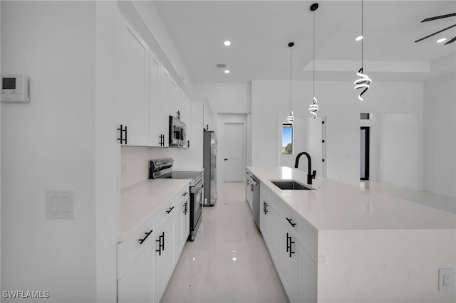 336 NE 25th St, Cape Coral, FL 33909 - kitchen featuring appliances with stainless steel finishes, a sink, a spacious island, white cabinets, and light countertops