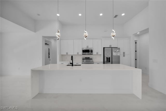 336 NE 25th St, Cape Coral, FL 33909 - kitchen featuring stainless steel appliances, a sink, a large island, white cabinetry, and light countertops