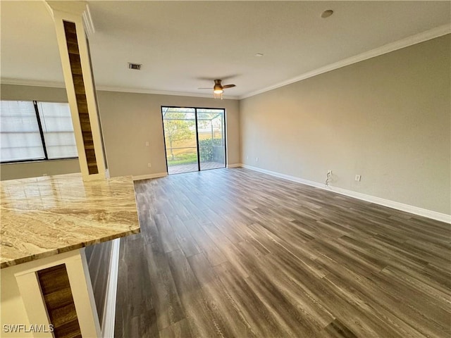 unfurnished living room featuring a ceiling fan, crown molding, baseboards, and dark wood-type flooring