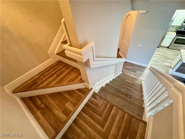 stairway featuring wood finished floors and baseboards