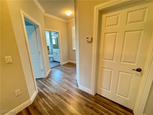 hall with crown molding, dark wood-style flooring, baseboards, and a textured wall