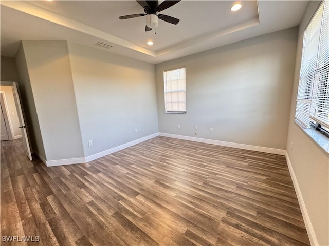 unfurnished room featuring recessed lighting, a tray ceiling, baseboards, ceiling fan, and wood finished floors
