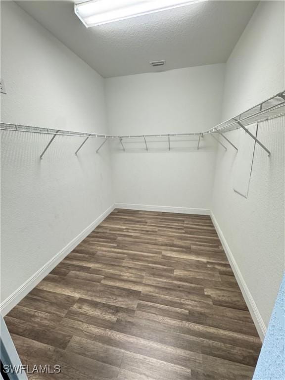 walk in closet with wood finished floors