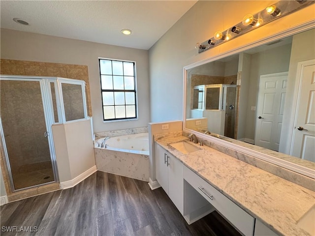 bathroom featuring a shower stall, wood finished floors, a whirlpool tub, and vanity
