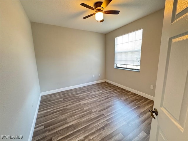 unfurnished bedroom with dark wood finished floors, baseboards, and a ceiling fan