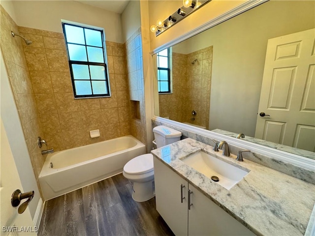 bathroom featuring wood finished floors, toilet, shower / bath combination, and vanity