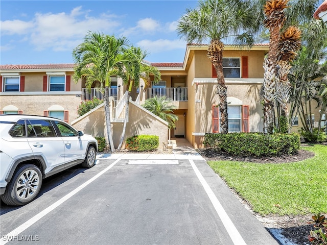 6670 Huntington Lakes Cir Unit 104, Naples, FL 34119 - view of property featuring uncovered parking and stairway