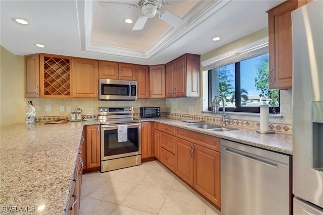 5015 Harbortown Ln Unit 204, Fort Myers, FL 33919 - kitchen featuring appliances with stainless steel finishes, a sink, recessed lighting, a tray ceiling, and decorative backsplash
