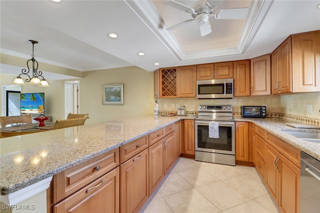 5015 Harbortown Ln Unit 204, Fort Myers, FL 33919 - kitchen featuring stainless steel appliances, a peninsula, a tray ceiling, light stone counters, and ornamental molding